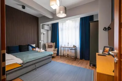 a bedroom with a bed and a chair and a window at Lux Flat next to Park with working space by Flat Mаnager in Sofia