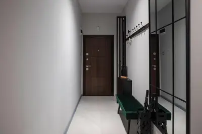 a hallway with a door and a green bench at Lux Flat next to Park with working space by Flat Mаnager in Sofia