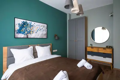 a bedroom with a large bed with blue walls at Lux Flat next to Park with working space by Flat Mаnager in Sofia
