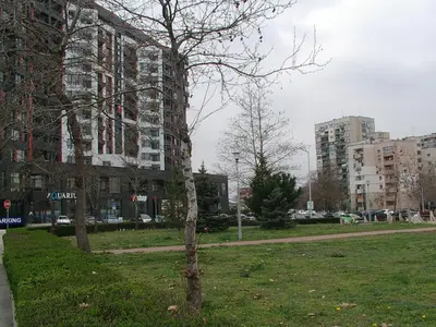 a tree in a park next to a building at Apartment KALINA with free private parking in Plovdiv