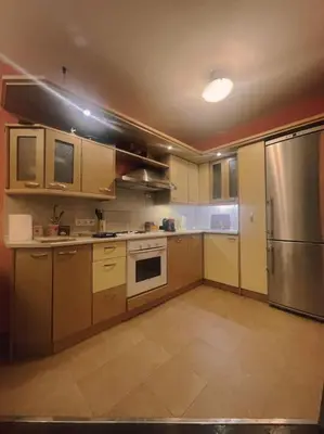 a kitchen with a stainless steel refrigerator and cabinets at A Colorful Apart for a Start in Sofia