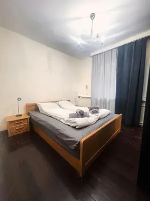a bedroom with a bed with a blue curtain at A Colorful Apart for a Start in Sofia