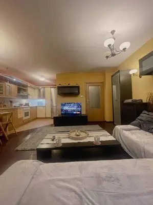 a living room with a table in the middle of a room at A Colorful Apart for a Start in Sofia