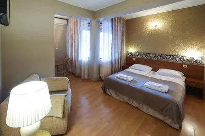 a hotel room with a bed and a chair at Complex Baroto in Gotse Delchev