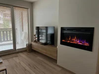 a living room with a tv and a fireplace at MidnightBlue Apartment in Bansko