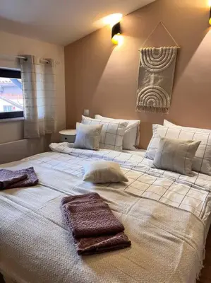 a large bed with two towels on top of it at Cozy 1 bedroom apartment next to the gondola in Bansko