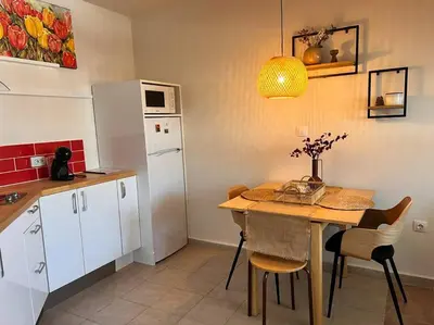 a kitchen with a table and a white refrigerator at Cozy 1 bedroom apartment next to the gondola in Bansko