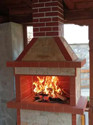 a brick oven with a fire inside of it at Стаи за гости Симона in Koprivshtitsa