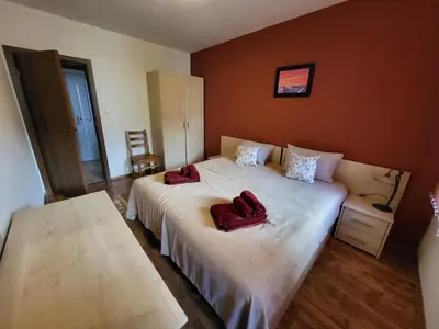 a bedroom with a bed with two red robes on it at Gri's place in Bansko