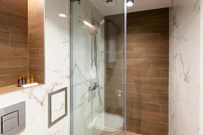 a bathroom with a glass shower with a toilet at Central View Apartment 1 in Blagoevgrad