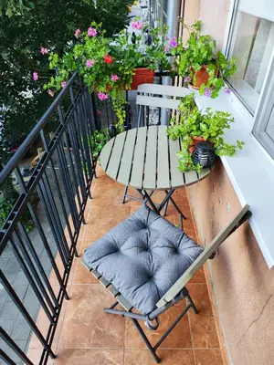 a chair sitting on a balcony with flowers at The Modern Suite Life with Terrace in Sofia