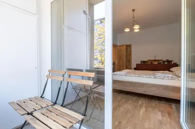 a room with a bed and a wooden chair at Urban Haven Retreat in Sofia