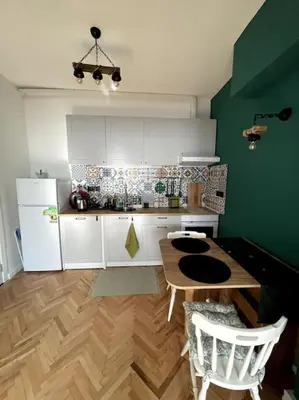 a kitchen with a wooden table and a white refrigerator at Green Flat Sofia Historic Center in Sofia