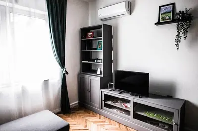 a living room with a flat screen tv on a entertainment center at Green Flat Sofia Historic Center in Sofia