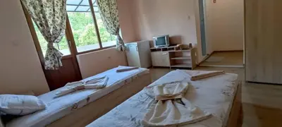 two twin beds in a room with a window at Guest House Proynovi in Kalofer