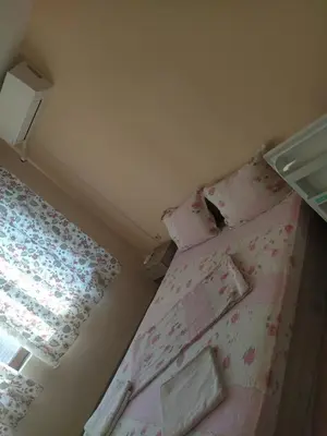 a small bedroom with a bed with pink sheets at Guest House Proynovi in Kalofer