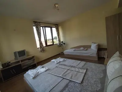 a hotel room with two beds and a television at Guest House Proynovi in Kalofer