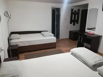 a bedroom with two beds and a desk and a television at Family Hotel 