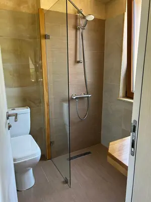 a bathroom with a toilet and a shower with a glass door at Villa Ema in Panichishte