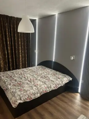a bedroom with a bed with a floral bedspread at Apartament G&M in Sandanski