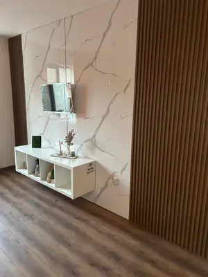 a living room with a tv on a wall at Apartament G&M in Sandanski