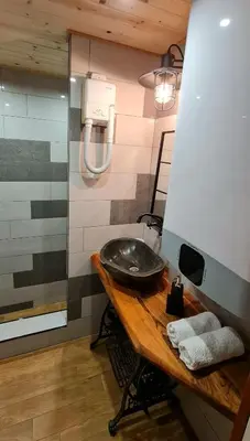 a bathroom with a sink on a wooden table at СПА къща за гости Каза Роза - Swiss Style Chalet Casa Rosa SPA Guest House in Kyustendil