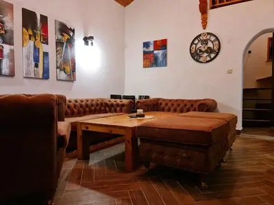 a room with couches and a table and a clock at СПА къща за гости Каза Роза - Swiss Style Chalet Casa Rosa SPA Guest House in Kyustendil