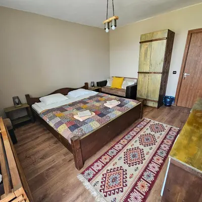a bedroom with a large bed and a rug at Guest House Belchin View in Belchin