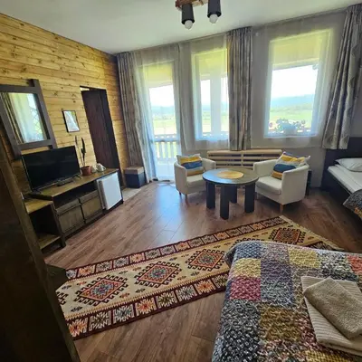 a living room with a bed and a table and chairs at Guest House Belchin View in Belchin