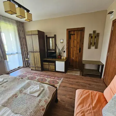 a large room with a bed and a mirror at Guest House Belchin View in Belchin