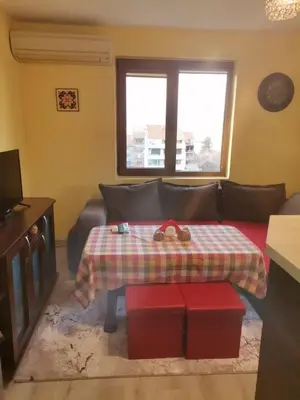 a living room with a table and a couch at Удобство in Petrich