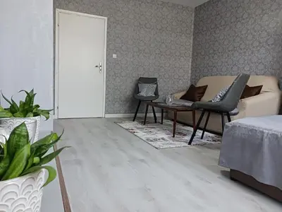 a living room with a couch and chairs and a table at Тристаен апартамент in Sofia