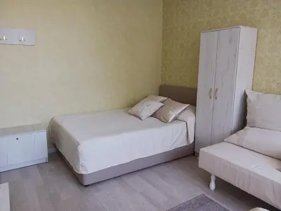 a bedroom with a bed and a cabinet and a couch at Тристаен апартамент in Sofia