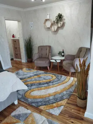 a living room with two chairs and a rug at Апартамент за гости Боляри 2 in Velingrad