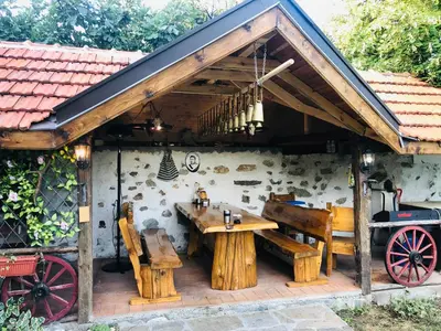 a pavilion with a wooden table and benches at Vila Teo in Vasil Levski