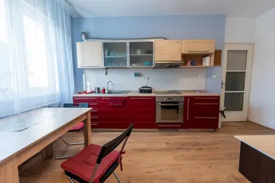 a kitchen with red cabinets and a table and chairs at 3-BR Central Residence in Sofia