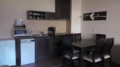 a kitchen with a table and chairs and a kitchen with a stove at Bansko Ski Apartments in Bansko Royal Towers in Bansko