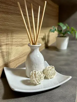a white vase on a plate with some straw at Apart 8 in Sandanski
