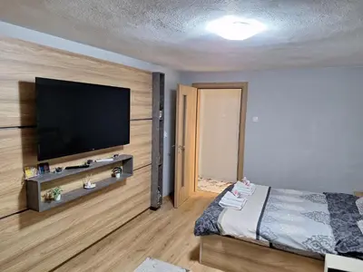 a bedroom with a flat screen tv on a wall at Apart 8 in Sandanski