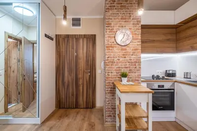 a kitchen with a brick wall and a wooden door at The Lemons Cozy Apartment in Sofia
