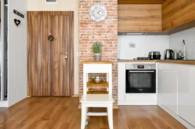 a kitchen with white counters and a brick wall at The Lemons Cozy Apartment in Sofia