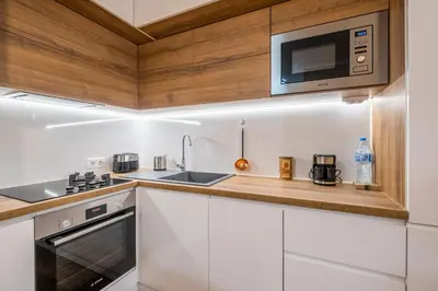 a kitchen with white cabinets and a microwave at The Lemons Cozy Apartment in Sofia