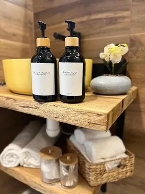 two bottles of soap on a shelf with towels at Rio Apart Deluxe in Sofia