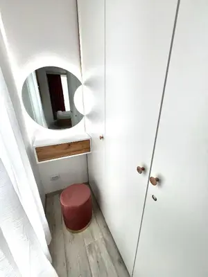 a small room with a red stool and a mirror at Rio Apart Deluxe in Sofia