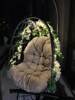 a white chair with flowers in a bird cage at Rio Apart Deluxe in Sofia