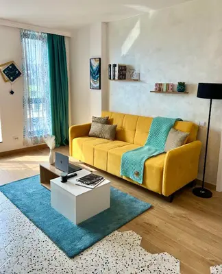 a living room with a yellow couch and a table at Rio Apart Deluxe in Sofia