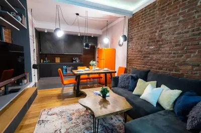 a living room with a couch and a brick wall at 2 Designer Central Apartments FREE Parking Spaces in Sofia