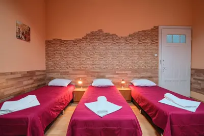 two beds in a room with red sheets at Guesthouse32 in Sofia