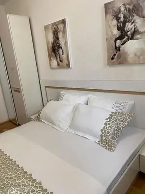 a bed in a bedroom with two paintings on the wall at Апартамент “Djanina 2” in Sandanski