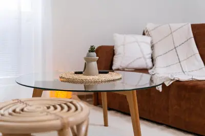 a glass coffee table in a living room with a couch at Stylish One-Bedroom Apartment in Plovdiv